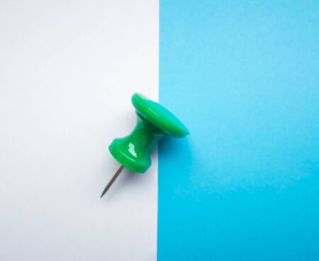 White and blue paper divided by a horizontal line, in the middle of the green pin. backgroundの写真素材