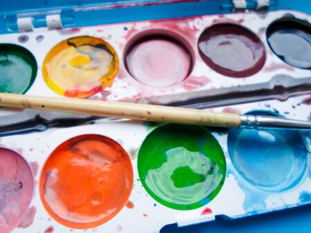 multicolored paints on a blue backgroundの写真素材