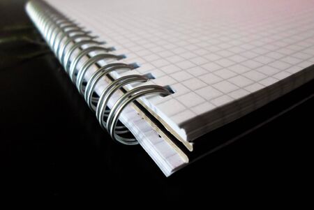 white checkered notepad on a black table. notebook with an iron spiral. back to schoolの写真素材