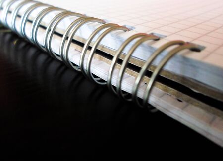 white checkered notepad on a black table. notebook with an iron spiral. back to school