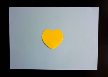 yellow heart on a dark white background. love concept
