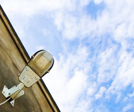 street lamp against the sky is attached to a concrete wall. electric lamp