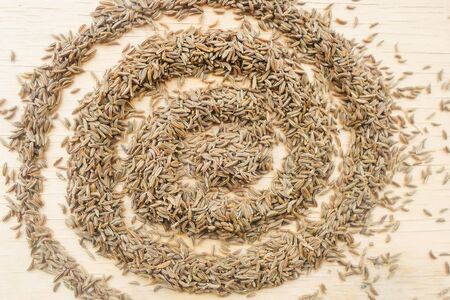 heap of caraway seeds on a wooden tableの写真素材