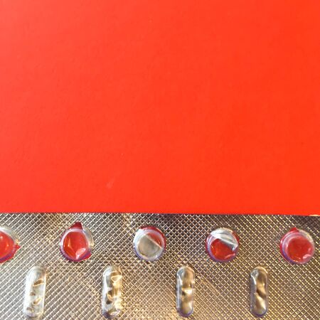 White pills on a red background. On a green background. View from above. Space for text.