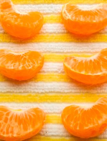 many slice of mandarin on a table with a napkin built in a rowの写真素材