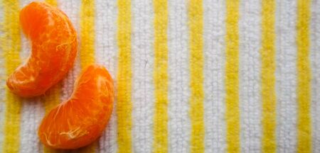 two pieces of mandarin on a table with a napkin