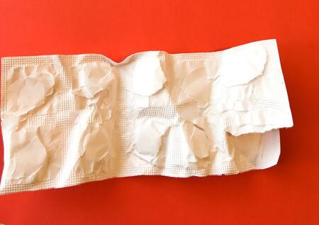 White pills on a red background. On a green background. View from above. Space for text.の写真素材