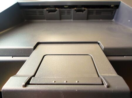 space for paper output on the printer. Closeup of a black printer part.
