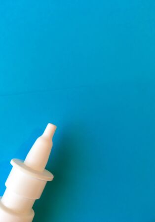 on a blue background is a white spray for the nose and place for text.の写真素材