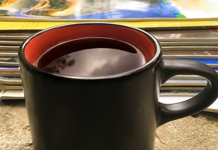 a stack of fresh morning Newspapers and a Cup of coffee against a background of greenery. Latest financial and business news in the daily newspaper.の写真素材