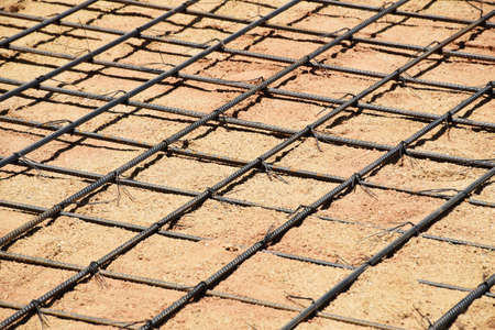 Pattern of round bar steel tied together placing on compressed sand, preparing for making concrete...