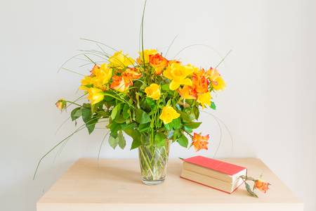 Bouquet of roses. Nearby is a book bookmark with flower roses.の写真素材
