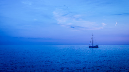 Sea surface is painted in ultramarine and blue colors sunset. Clear skie with some clouds.の写真素材