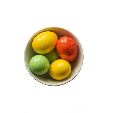 Painted colorful eggs in bowl. Feast of Easter. Isolated objects. View from aboveの写真素材