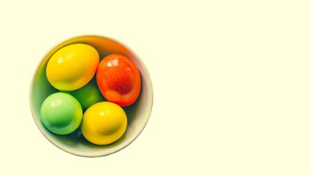 Painted colorful eggs in bowl. Feast of Easter. Isolated objects. View from above, copy space.の写真素材