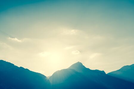 The sun goes down to the tops of mountains. Filter soft light. Photo, abstract landscapeの写真素材