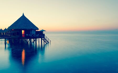 Panorama of tropical island resort with overwater bungalows at night.  Ari Atoll.の写真素材