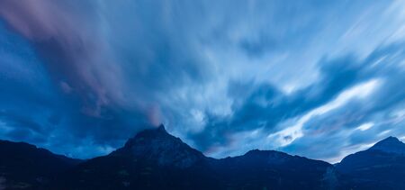 Sunset cloudy sky over mountains. Long exposure.の写真素材