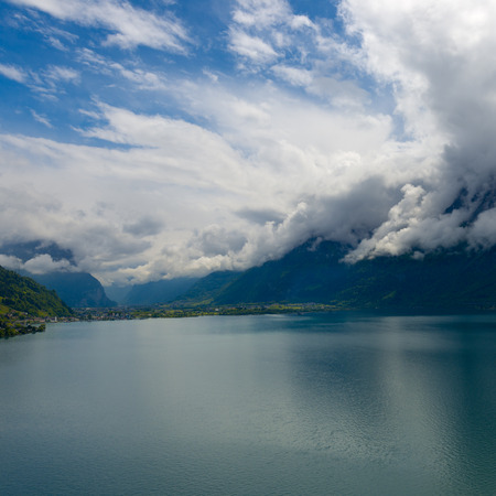 Impressive clouds over the mountains. Dramatic Sky.  Lake between the Swiss Alpsの写真素材