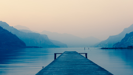 Panorama of mountain lake at sunset. Mountain range in the background. Wooden pier.の写真素材
