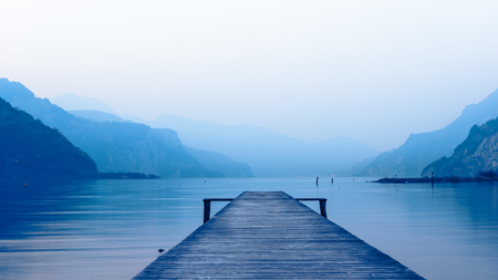 Panorama of mountain lake at sunset. Mountain range in the background. Wooden pier.の写真素材