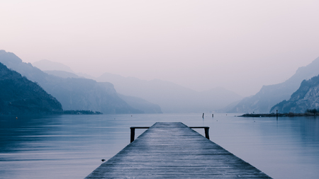 Panorama of mountain lake at sunset. Mountain range in the background. Wooden pier.の写真素材