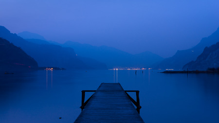 Panorama of mountain lake at sunset. Mountain range in the background. Wooden pier.の写真素材