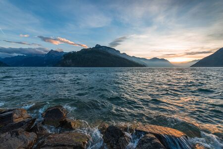 Sunset on the lake on a windy day. The play of light and shadow in the mountainsの写真素材