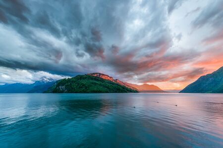 Sunset over  mountains and lake. Special bright colors before  storm, windyの写真素材