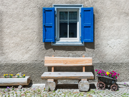 Window with flower  on ledge in a village, eastern of Switzerland. Small truck, stylized as flower pot.の写真素材