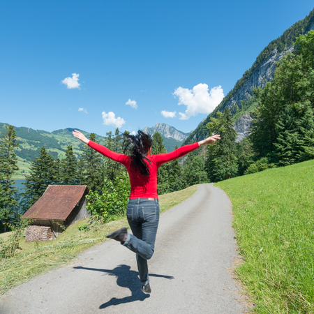 To jump up joyful woman. Mountain landscape summer day.の写真素材