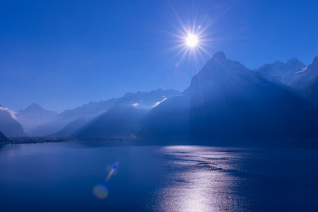Mountains in the mist blue color. Bright sunrays in a cloudless sky. Lens Flareの写真素材
