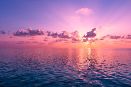 Magnificent panorama of sunset over the ocean. Rays of the sun shine through the clouds.の写真素材