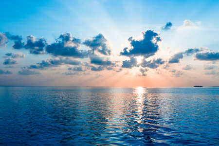 Magnificent panorama of sunset over the ocean. Rays of the sun shine through the clouds.の写真素材