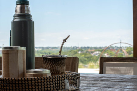 Coffee cup and bottle on wooden table with nature view backgroundの写真素材