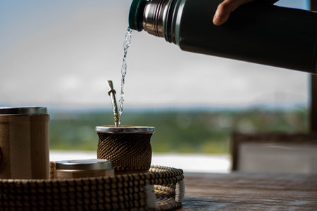 Pouring water from a bottle into a pot on the terraceの写真素材