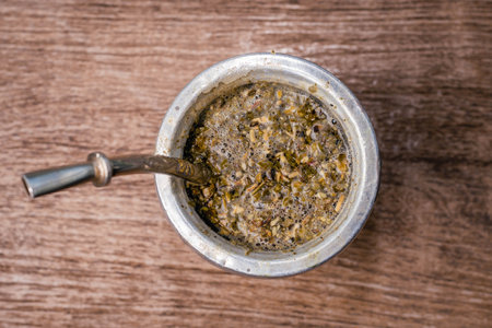 Top view of an old metal cup full of tobacco on a wooden tableの写真素材