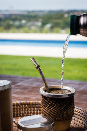 Pouring hot coffee into a cup on the terrace by the pool.の写真素材