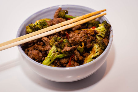 Stir-fried beef with broccoli and chopsticks in a bowlの写真素材