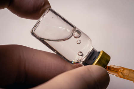 close-up of vaccine vial and needle with dropsの写真素材