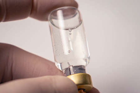 close-up of vaccine vial and needle with dropsの写真素材