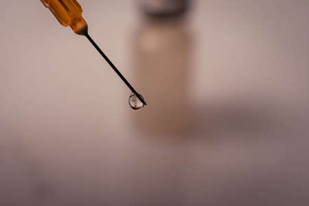close-up of vaccine vial and needle with dropsの写真素材