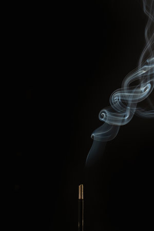 Smoke from incense stick on a black background with copy spaceの写真素材