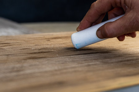 Close-up of a hand holding a paint roller over a wooden boardの写真素材