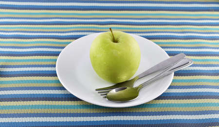 Green apple and yellow measuring tape concept for healthy diet and body weight control.の写真素材