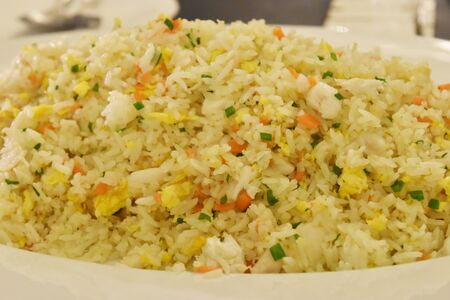 fried rice in dish on wooden table in restaurant.の写真素材