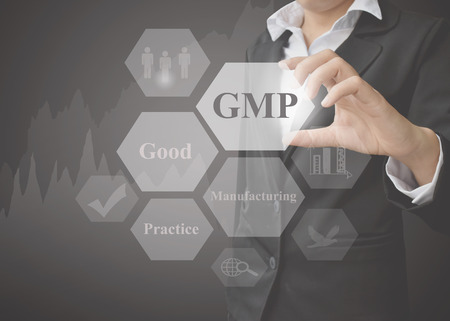 Business woman showing presentation meaning of GMP concept (Good Manufacturing Practice) a principle on black background. Idea for used in manufacturing and training. の写真素材