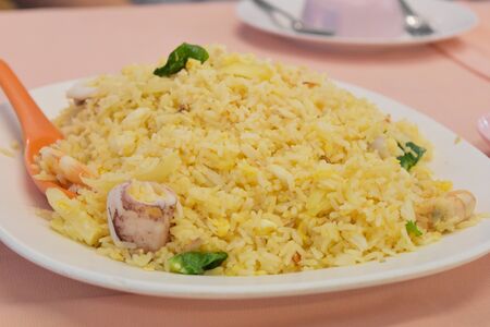 Fried Rice with vegetables and squid on plate in restaurant, Thai food style.の写真素材