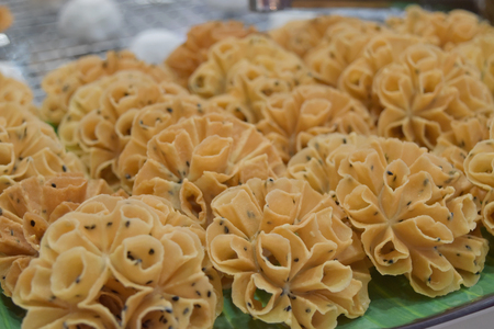 Crispy Lotus Blossom Cookie on banana leaf.  (Thailand desserts or "Dok JoK sweet. (made from flour, coconut milk, sugar, salt, sesame)の写真素材