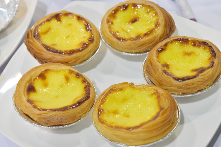 Egg tart with bread small cup and butter on white plate in the restaurant. Fast food for the working...